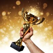 Man holding up a gold trophy cup