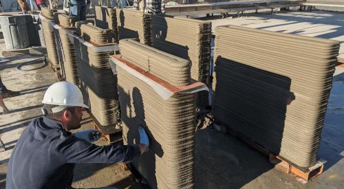 Man with 3D construction printed building in progress