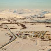 Aerial view of snow covered mountains and residential area on the outskirts of Nome, Alaska