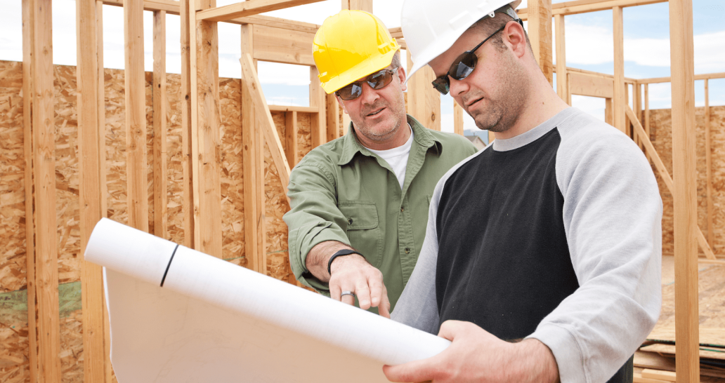 Builders with roll of house plans discuss how to make homes more affordable