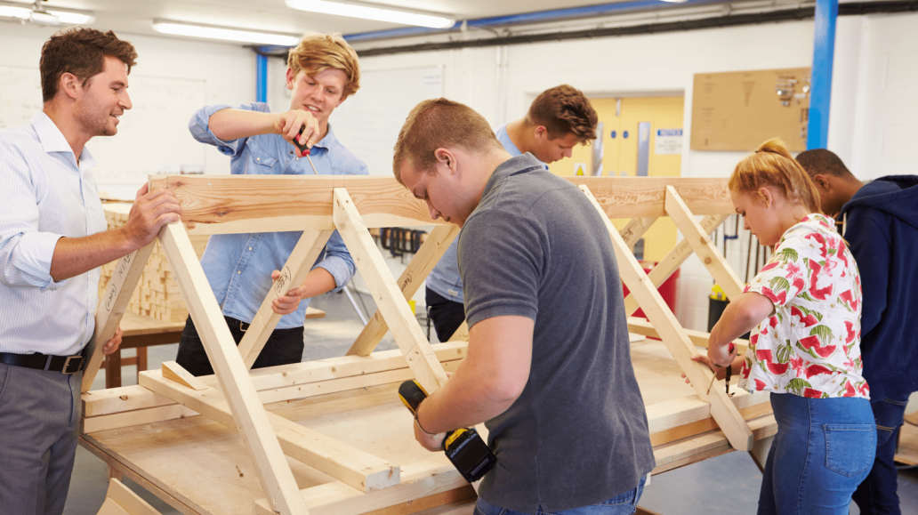 Students learning carpentry skills in a construction trades class