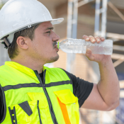 Construction worker drinking bottle of water during heat