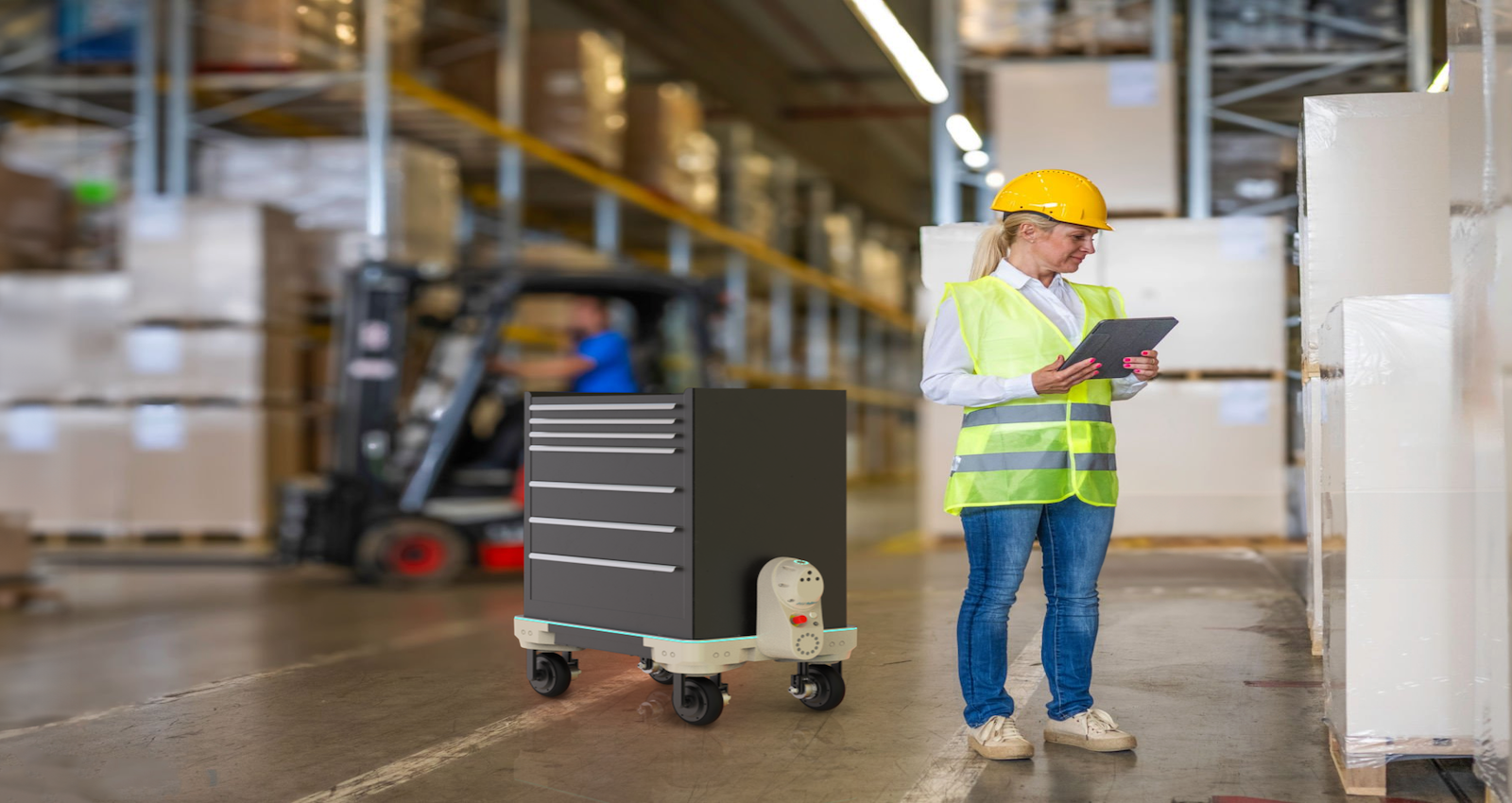 Warehouse worker in hardhat and yellow vest uses Kilo robotic flatbed