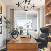 Spacious home office with floor-to-ceiling bookshelves and a wood desk