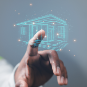 Man's hand reaching toward building information modeling home floating in air